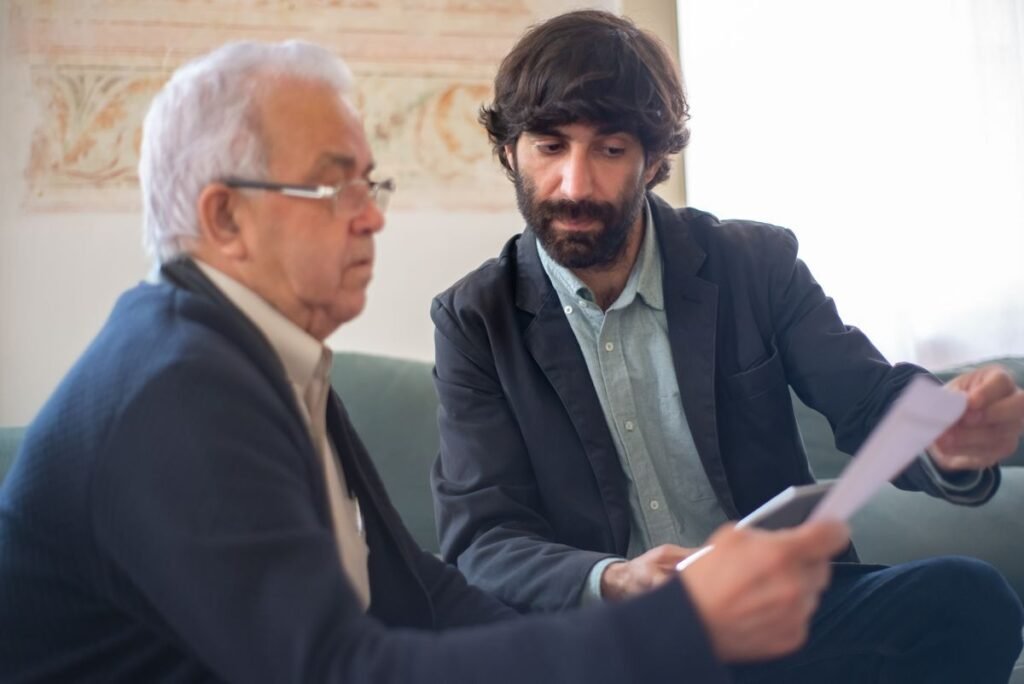 A professional reviewing paperwork with an older client during a benefits consultation